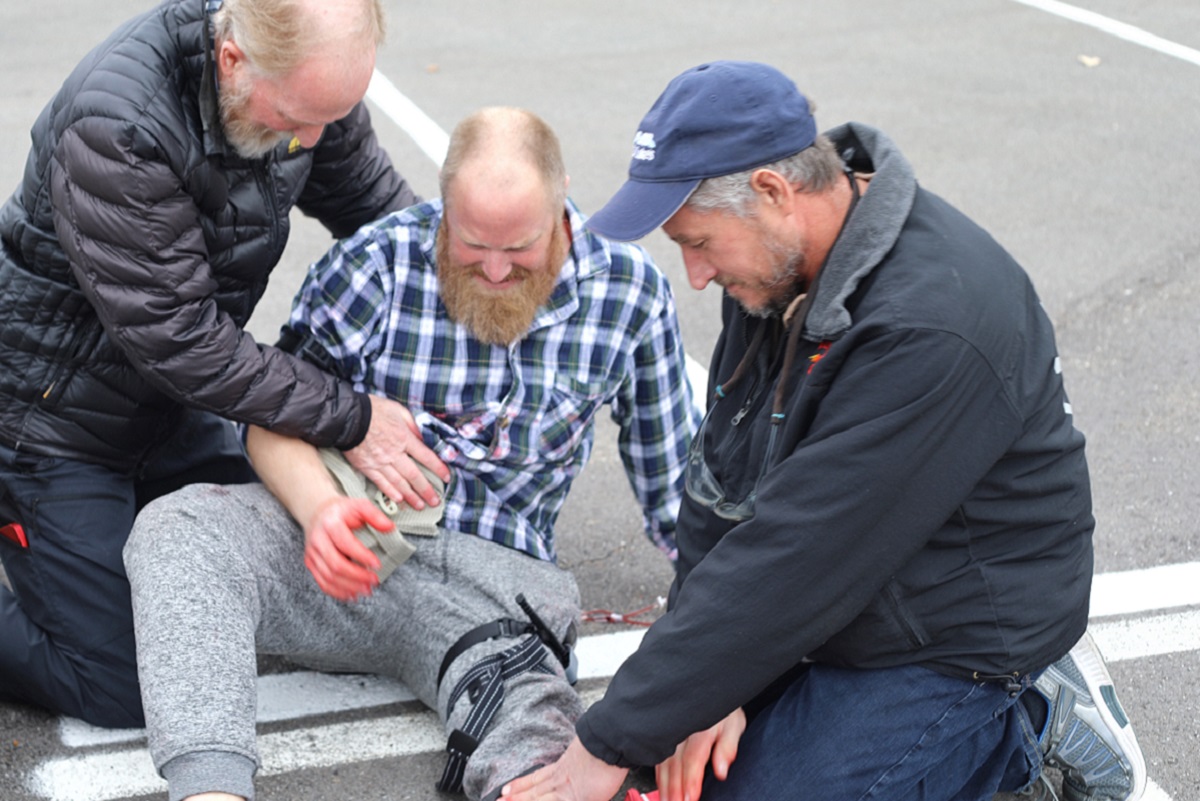 Attendees assess a "patient" during Tactical Combat Casualty Care, a simulation of an active shooter scenario.